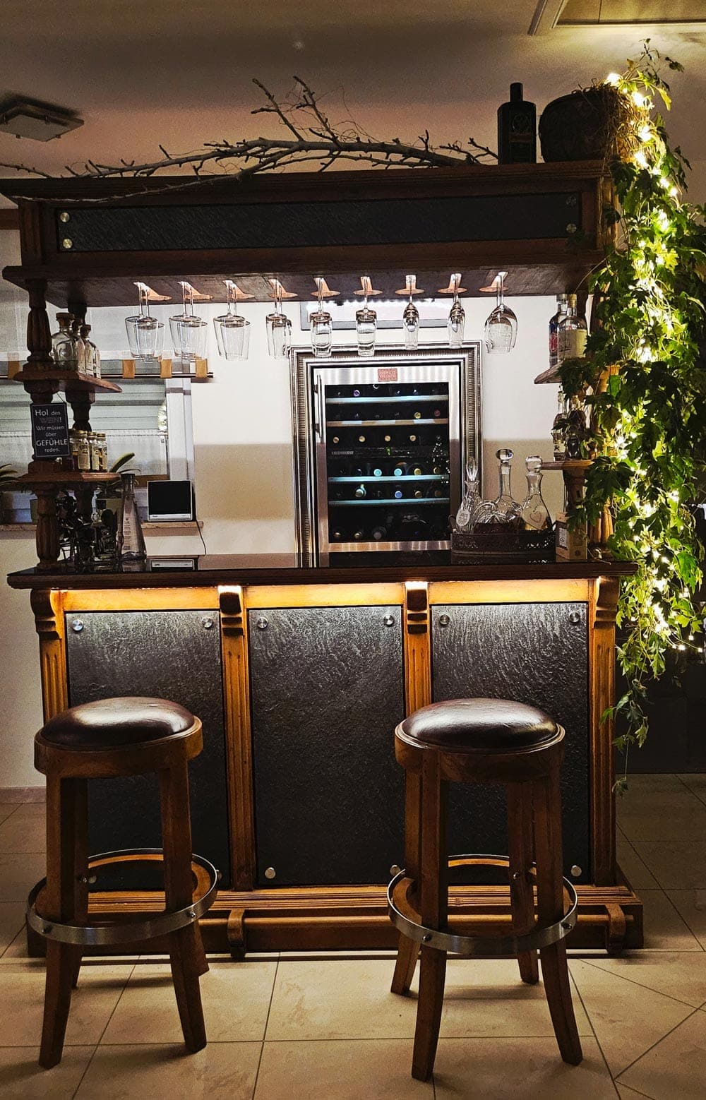 Hausbar mit Steinfurnier-Fronten und LED-Streiflicht am Abend