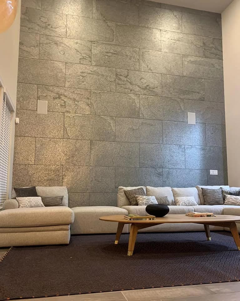 Raumhohe Steinwand hinter der Sitzgruppe im Wohnzimmer