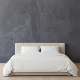 Schlafzimmerwand aus Echtsteinfurnier Schwarzes Gries hinter dem Bett